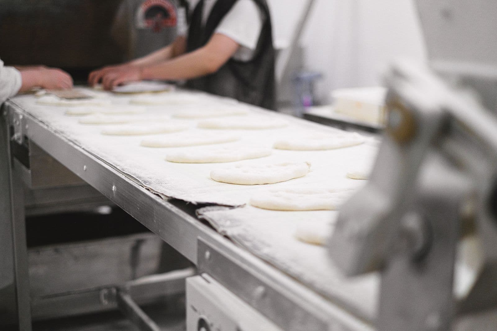 Dough pieces travelling a bakery conveyor